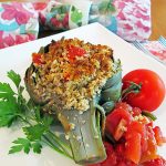 stuffed artichoke on plate with tomato